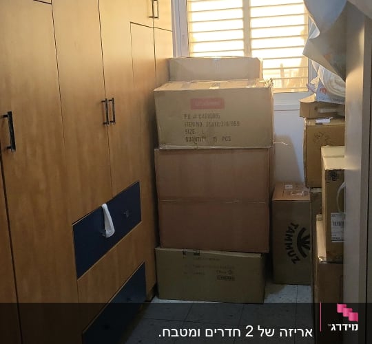 ארונות עץ וארגזים מסודרים בחדר קטן